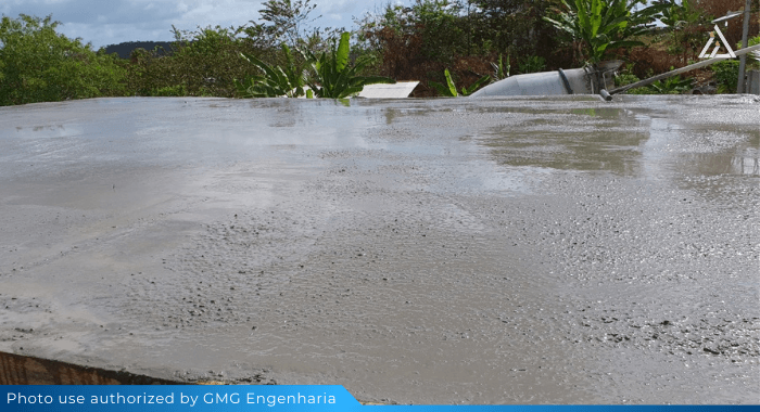 The photo shows an angle of a construciton site with freshly poured concrete. The newly made foundation has several puddles of water at its surface. This is an example of bleeding in concrete. To avoid this phenomenon, an air-entraining agent can be used in the concrete mix design