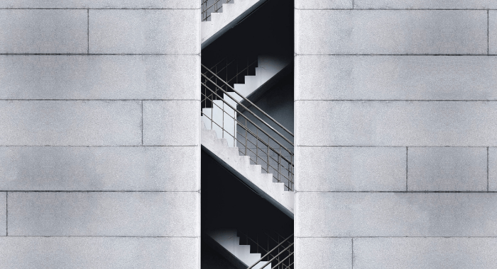 This is the feature image of the blog post Top 3 Reasons to use Air-Entraining Agents in Concrete. The image is a picture of the side of a building, showing its intended architectural feature of exposed concrete. The center of the image shows concrete stairs giving ample acess to the several floors of the building.