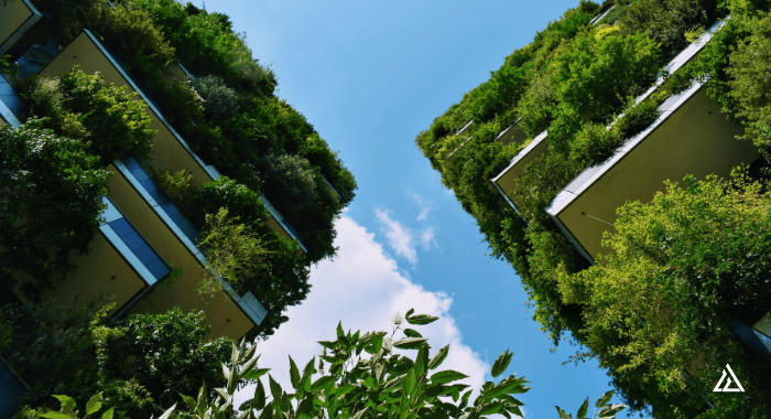 The image shows 2 modern concrete buildings at an angle from the ground up. They are adorned with innumerous plants and greenery. The blue sky is visible between them. On Earth Day, this image represents the progress done so far towards a greener and more sustainable future in the concrete industry. But the challenges continue. There is much to be done to decarbonize the concrete industry as a whole.